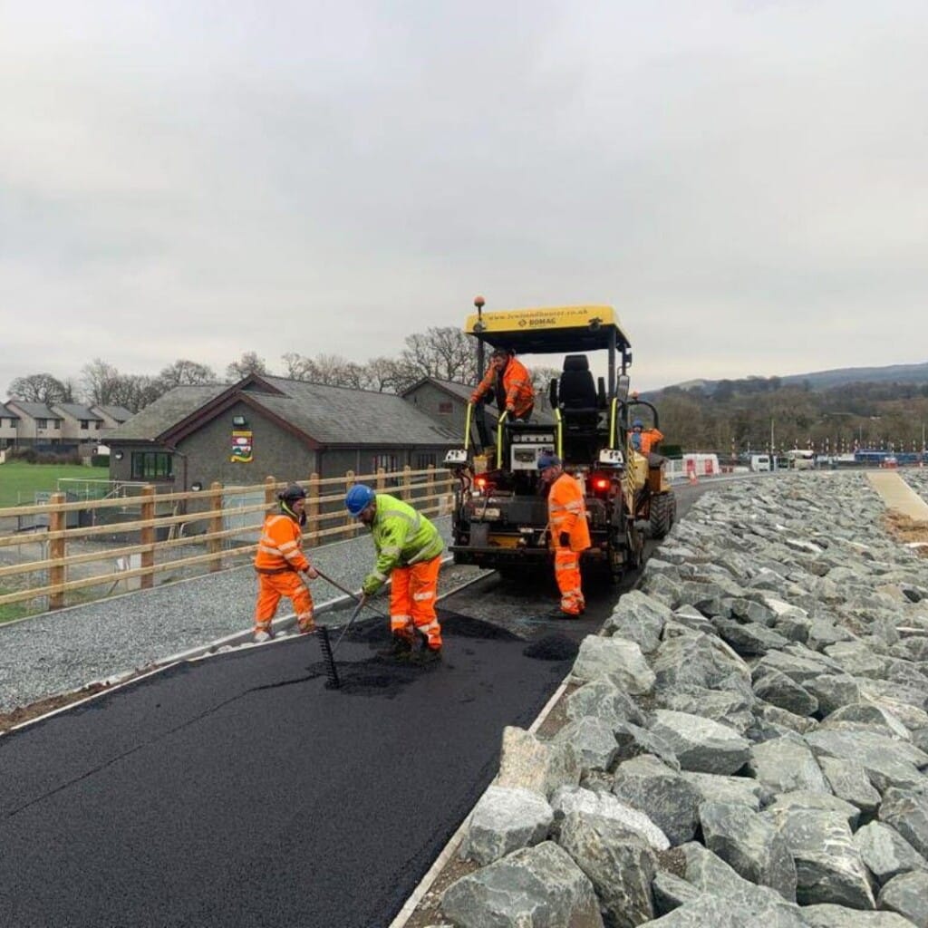 Construction workers lay a path